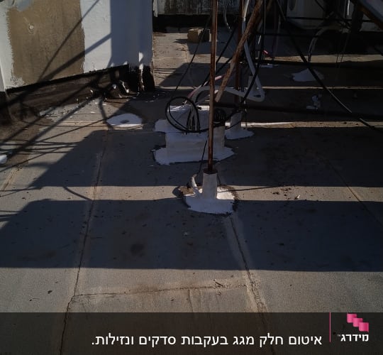 איטום גג עם חומר לבן סביב צינורות